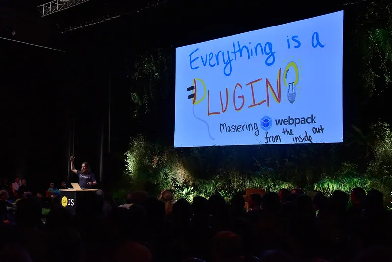Sean Larkin in front of the giant screen showing an hand drawn picture with the talk title